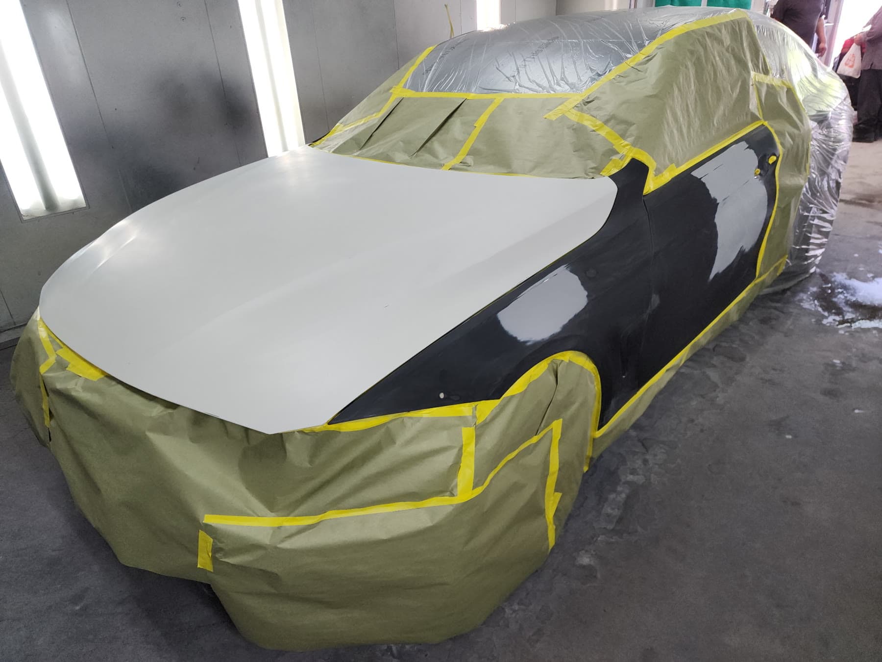 Black BMW 430i masked and primed during paint preparation